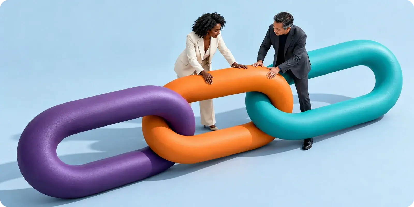 sculpture de grands maillons colorés que deux personnes relient